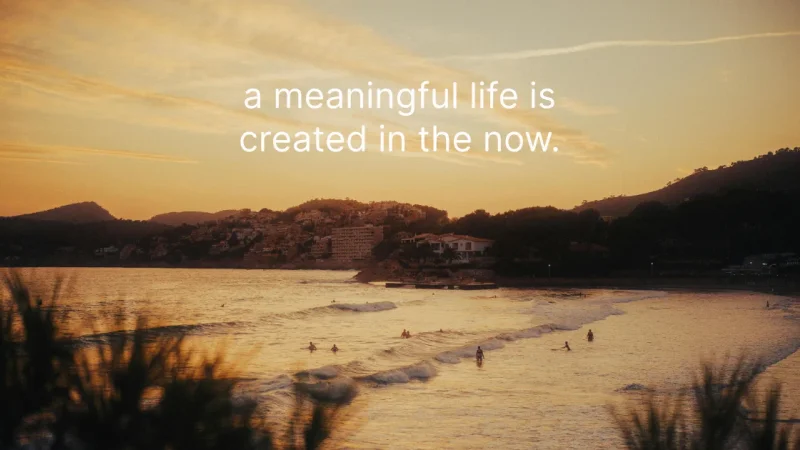 Surfers in the water at a beach at golden hour, with the words “a meaningful life is created in the now.”
