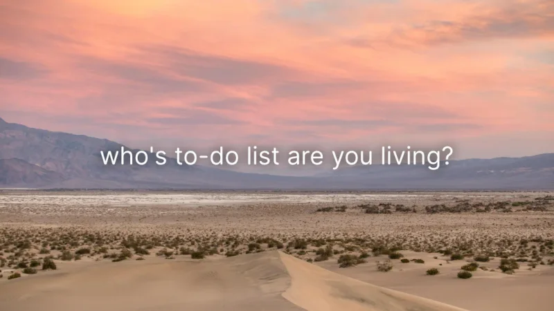 Sand dunes and distant mountains under a pink sunset sky, with the words “who’s to-do list are you living?”